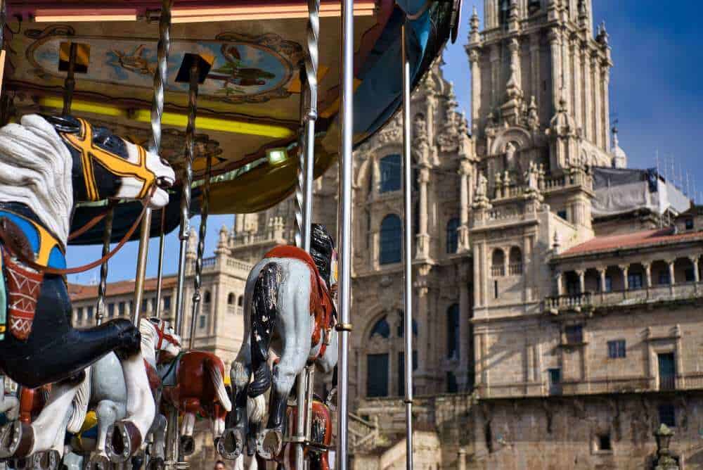 santiago cathedral during a festival with rides in the foreground